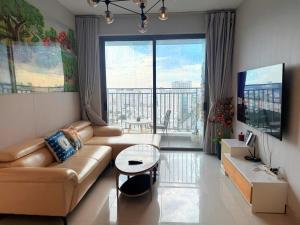 un soggiorno con un divano e una grande finestra di Stay With Me CBD Apartment - Rivergate Building ad Ho Chi Minh