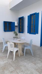 a table and two chairs and blue windows at Petite maison typique à 2 pas de la mer in Sousse +33 photos