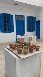 a bunch of bowls sitting on a table with blue doors at Petite maison typique à 2 pas de la mer in Sousse