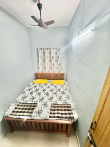 a bed in a room with a ceiling fan at ROB'S INN Groupstay 