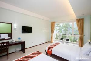 a bedroom with a bed and a television and a balcony at Casa Monte Rosa in Puncak +119 photos