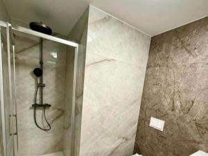 une douche avec une porte vitrée dans une salle de bain dans l'établissement One-Bedroom Apartment With Terrace, à Sreser