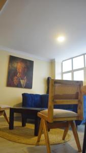 un soggiorno con un divano blu e una sedia di Karen Plains Hotel Nairobi a Nairobi