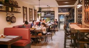 a group of people sitting at tables in a restaurant at Casa Rubin in Angatan