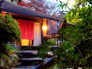 una pequeña casa con una cortina roja y algunas escaleras en Yutorelo-an en Hakone