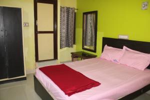 a bedroom with a large bed with green walls at Arunachala Residency in Tiruvannāmalai +4 photos