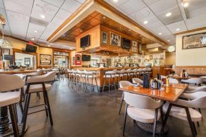 Un restaurante con mesas y sillas y un bar. en Ramada by Wyndham State College Hotel & Conference Center, en State College