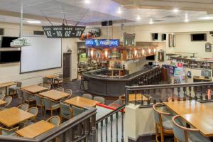 a restaurant with tables and chairs and a bar at Ramada by Wyndham Kelowna Hotel & Conference Center in Kelowna