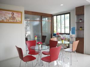 a dining room with red chairs and a table at Regent Room Hotel in Surat Thani