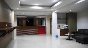 a living room with a black couch and a kitchen at Regent Room Hotel in Surat Thani