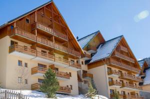 an apartment building with snow on the ground at Résidence Goélia Les Chalets Valoria in Valloire