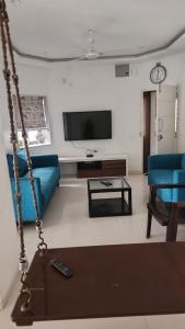 a living room with a blue couch and a tv at Samta in Vadodara +8 photos