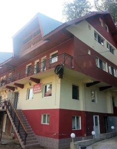 um edifício vermelho e branco com escadas em Vila MDM em Straja
