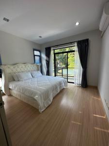 Un dormitorio con una cama y una ventana grande en บ้านเดี่ยวหางดง ย่านมหาวิทยาลัยนอร์ทเชียงใหม่, en Ban Phae Buak Ha