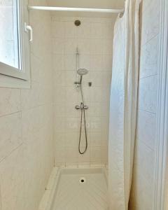 a shower with a shower curtain in a bathroom at Le Refuge du Port in Étaples