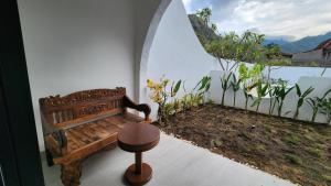 a bench and a stool in a room with a window at Bnaya Villas Riverside in Amed