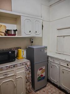a small kitchen with a refrigerator and a microwave at Swahiba's 254 in Keruguya