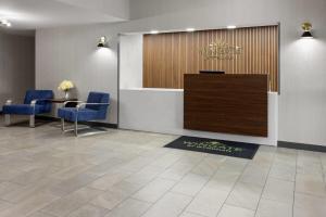 a lobby with a reception desk and blue chairs at Wingate by Wyndham Grove City in Grove City