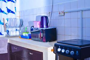 a kitchen counter with a microwave and a stove at Eldo oasis in Eldoret +12 photos
