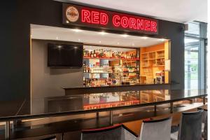 un bar dans un restaurant avec un coin rouge dans l'établissement Ramada by Wyndham Essen, à Essen