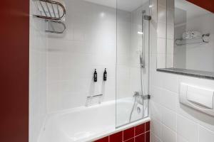 Un baño con ducha con puerta de cristal. en Ramada by Wyndham Essen, en Essen