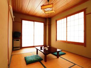 a living room with a table and two windows at Chouchinya in Nozawa Onsen