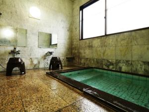 La salle de bains est pourvue d'une piscine et d'un lavabo. dans l'établissement Chouchinya, à Nozawa Onsen