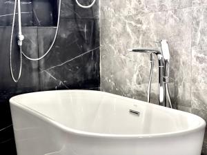a white bath tub in a bathroom with a shower at Sky Hotel Sihanoukville - Free laundry in Sihanoukville