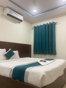 a bedroom with a bed with a blue curtain at At Home Hotel Darbar in Hyderabad