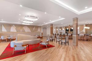 a lobby with tables and chairs and a waiting room at Cambria Hotel & Suites Plymouth in Plymouth