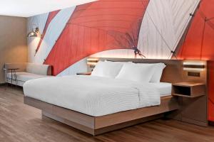 a bedroom with a large bed with a red umbrella mural at Cambria Hotel & Suites Plymouth in Plymouth +55 photos