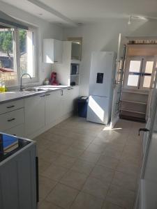 een keuken met een witte koelkast en een tegelvloer bij Maison agreable in Blois