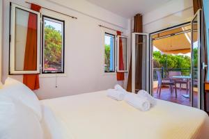 a bedroom with a bed with two towels on it at Romanos Beach Villas in Romanós