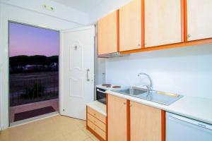 a kitchen with a sink and a stove and a window at Romanos Beach Villas in Romanu