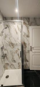 a bathroom with a shower with a marble wall at Bright apartment in Menton in Menton