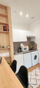 a kitchen with white cabinets and a table with chairs at Bright apartment in Menton in Menton +13 photos