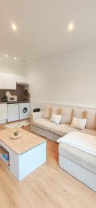 a living room with two white couches and a table at Bright apartment in Menton in Menton