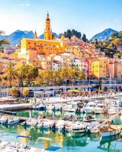 a harbor in a city with boats in the water at Bright apartment in Menton in Menton