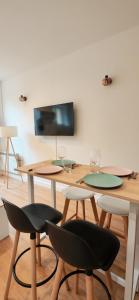 a table with two chairs and a tv on a wall at Bright apartment in Menton in Menton