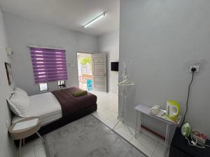 a small bedroom with a bed and a bathroom at Cahaya roomstay in Kangar