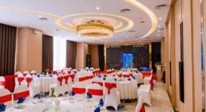 Lóc ÐaにあるKhach san Toan Thang Stoneの白いテーブルと赤と白の椅子が備わる宴会場 +233枚の写真