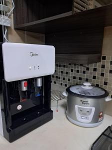 a coffee maker sitting on a counter next to a mixer at Homestay Putrajaya Ayer 8 Elzahra Suites With Wi Fi in Putrajaya