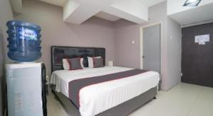 une chambre avec un grand lit et un tonneau bleu dans l'établissement OYO 94024 Sentraland karawang By Aswin, à Poponcal 2