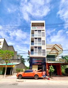 an orange truck parked in front of a tall building at Nhà Nghỉ Thành Duy in Quang Ngai