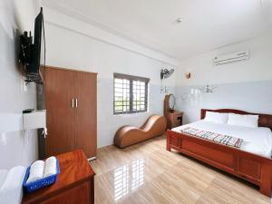 a bedroom with a bed and a flat screen tv at Nhà Nghỉ Thành Duy in Quang Ngai +11 photos