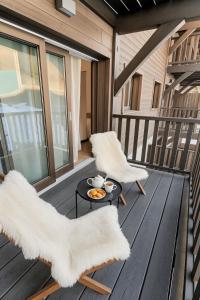 a balcony with two chairs and a coffee table at FRGK "Charme alpin et confort moderne" in Saint-Étienne-de-Tinée