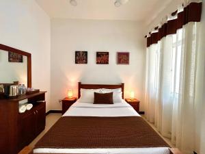 a bedroom with a large bed and two lamps on tables at Terrace Kandy in Kandy