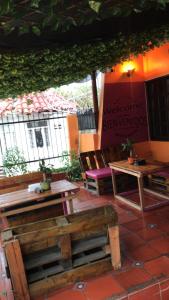 a patio with wooden benches and tables and a sign at Habitación Privada con Aire in Cartagena de Indias