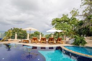a pool with chairs and tables and umbrellas at Chaweng Bay View Resort by Smith & Appy in Ko Samui