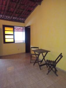 a room with a table and a chair in it at Hostel Mangabeira in Cachoeira
